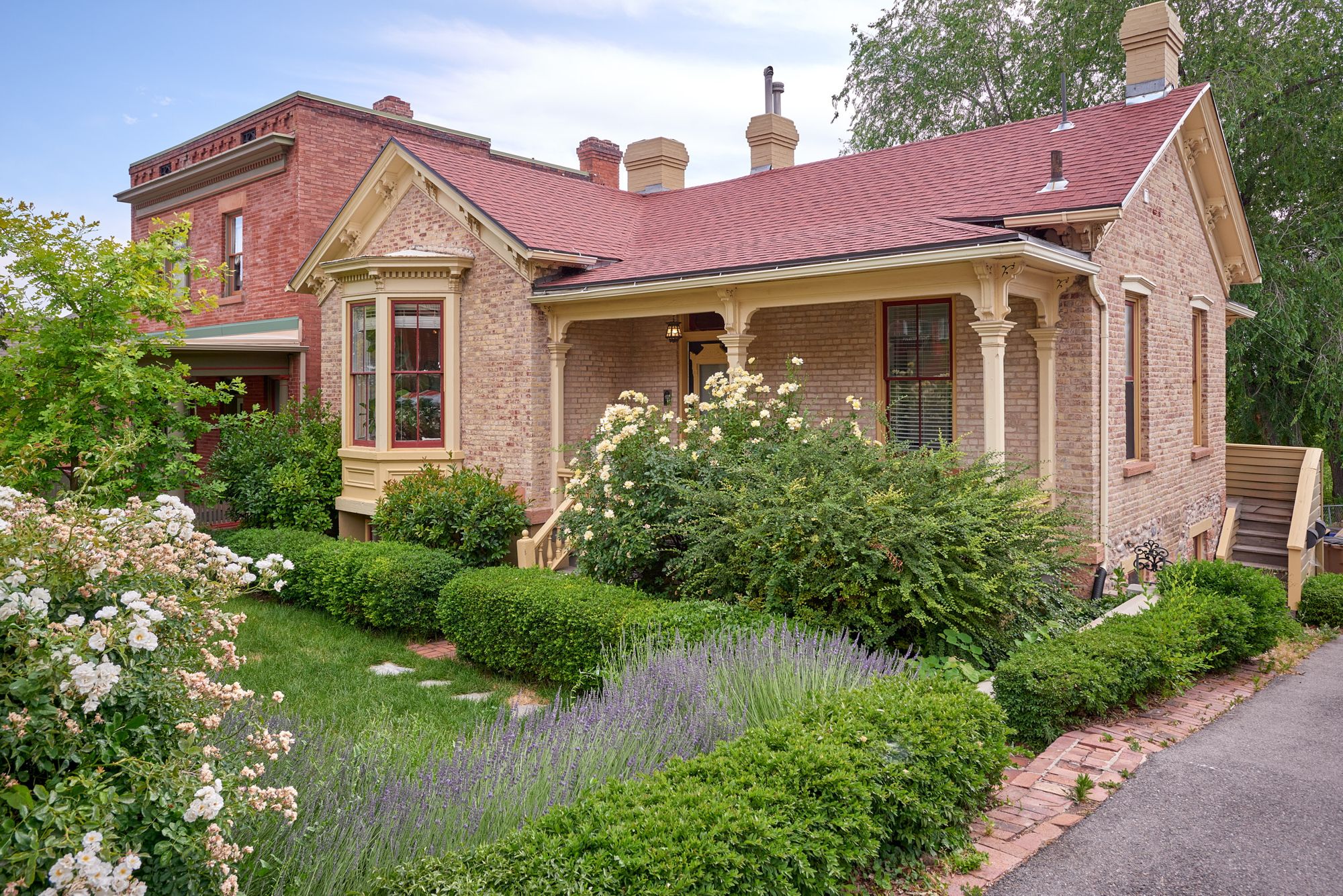 Brick Victorian on N Quince St at sunset, framed by white roses